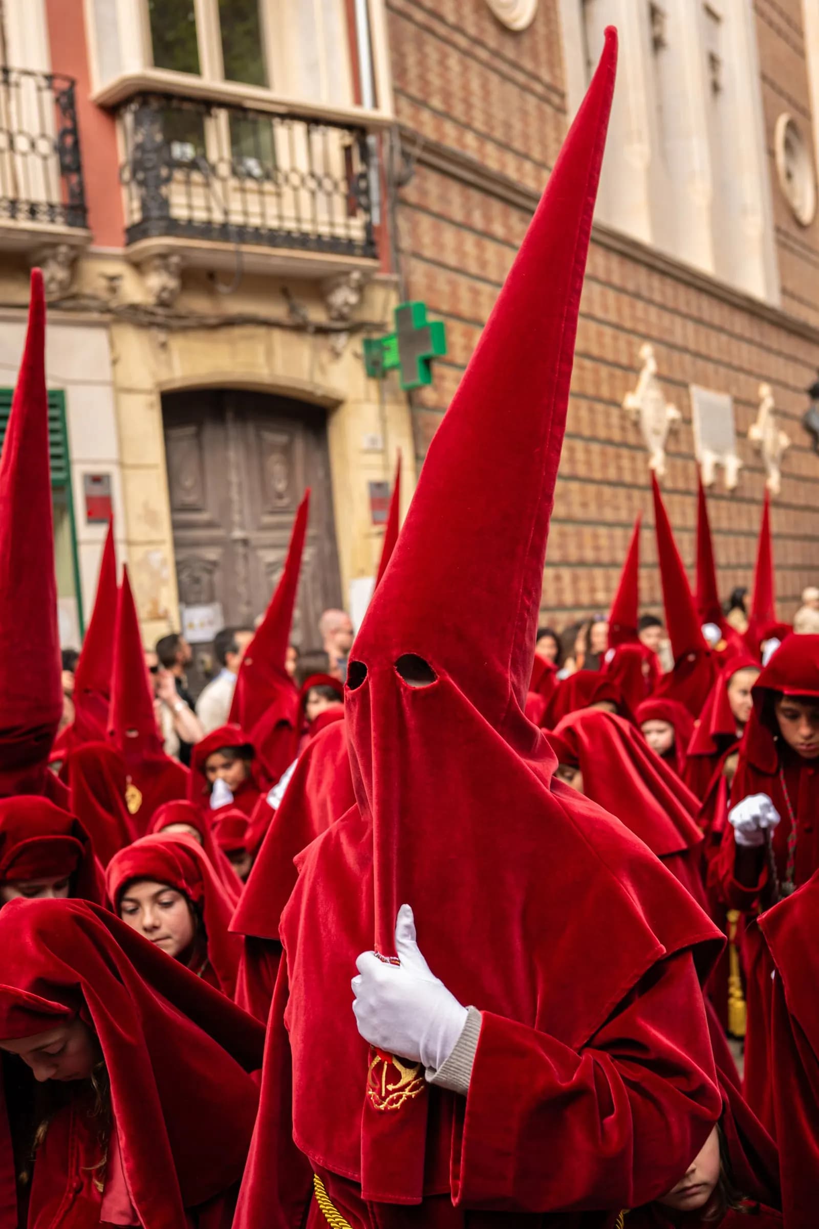 Deelnemers in ceremoniële gewaden tijdens een Semana Santa-processie in de straten van Málaga