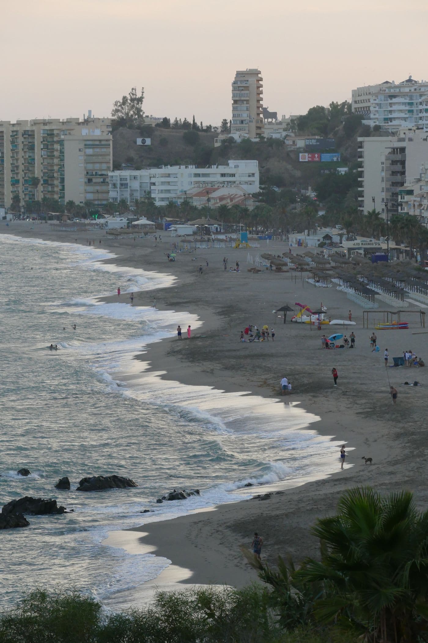 Golven op het strand met de skyline van Fuengirola